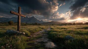 Serene pathway with a wooden cross at sunset in a mountainous landscape photo