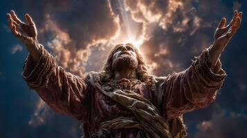Statue of a religious figure with outstretched arms against a dramatic sky at dusk photo
