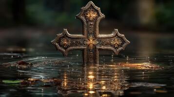 Decorative cross partially submerged in water with ripples and autumn leaves in a serene outdoor setting photo