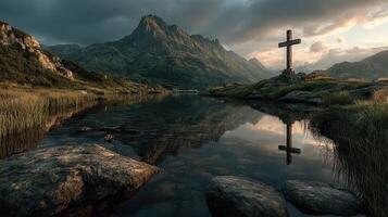 Serene mountain landscape at dusk with a cross near a reflective lake surrounded by rocky terrain photo