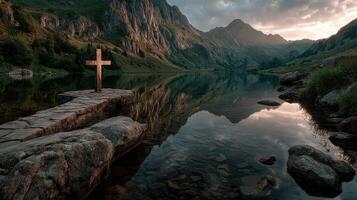 Serene mountain lake at sunset with a wooden cross reflecting on calm waters in a tranquil landscape photo