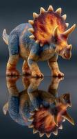 Colorful triceratops toy figure standing on reflective surface in a studio setting photo