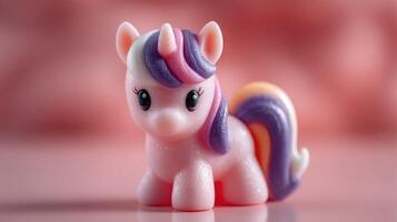 Colorful unicorn figurine sits on a soft pink surface, capturing the magic of childhood joy in a playful setting photo
