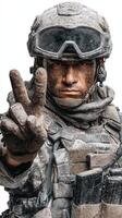 Soldier demonstrating peace sign after a successful mission in a dusty environment during daytime photo