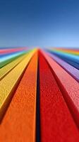 Vibrant colors of foam strips create a rainbow landscape under a clear blue sky in a sunny outdoor setting photo