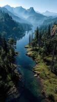 Mountain river winding through forests and valleys in early morning light under a clear sky photo
