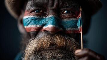 Portrait of an elderly man with painted face holding a flag, showcasing cultural pride and identity photo