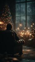Cozy evening by the window with a person relaxing in candlelight and snowfall outside in a dimly lit room photo