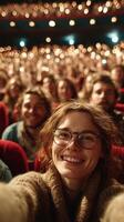 Excited audience member takes selfie at a lively theater performance during evening entertainment event photo