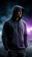 Man in hooded sweatshirt stands confidently against a dramatic, colorful background at night photo