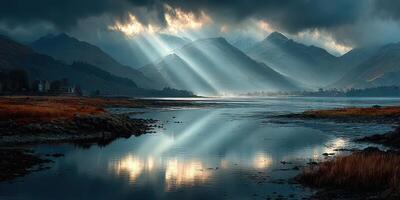 Dramatic sunlight breaks through clouds over a serene lake near rugged mountains at dawn photo