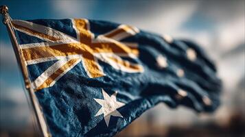 Australian flag waving against a blue sky with clouds during a bright sunny day photo