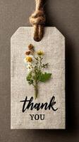 Natural thank you tag features flower arrangement on rustic background with twine photo