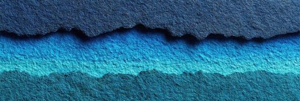 Colorful torn paper edges create a layered ocean effect with shades of blue in a creative artwork photo