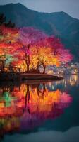 Autumn colors reflect on serene lake at twilight near mountains illuminating the beauty of nature photo