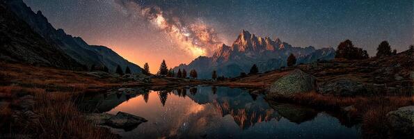 Starlit mountain landscape reflects in calm lake at dusk in serene natural setting photo
