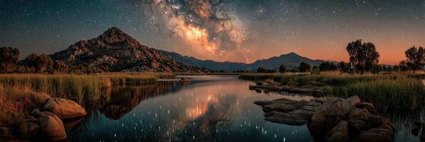 Majestic night sky over serene lake surrounded by mountains at twilight with stars shining bright photo