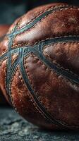 Close-up view of a textured leather basketball resting on a dark surface, highlighting its craftsmanship and details during sports practice photo