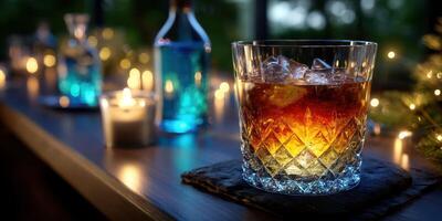 Elegant glass of whiskey on a wooden bar surrounded by lit candles and colorful bottles during an evening setting photo