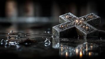 Cross reflection on wet surface illuminated by dim light near dark background, creating an atmospheric effect and sense of depth photo