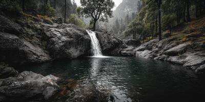 Waterfall cascading into a serene pool surrounded by trees in the mountains during a misty morning photo