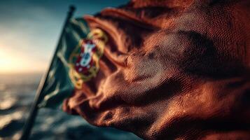 Flag of Portugal billowing in the wind over the ocean at sunset capturing a moment of national pride photo