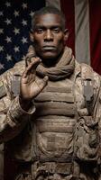 Portrait of a soldier standing confidently against an American flag backdrop while saluting photo