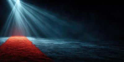 Spotlight illuminating a red carpet pathway within an empty dark venue during an event preparation photo
