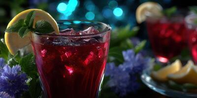 Refreshing red beverage garnished with lemon and mint surrounded by vibrant flowers at a summer gathering photo