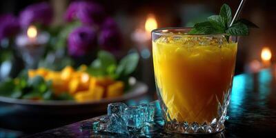 Refreshing mango cocktail served with mint leaves and ice in a cozy setting with flowers and candles photo