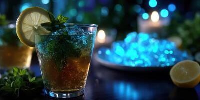 Refreshing mint cocktail served with lemon on a dark bar table surrounded by soft blue lights and glowing ice photo