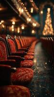 Elegant red velvet seats arranged in a theater with soft lighting and a decorated Christmas tree in the background during the festive season photo