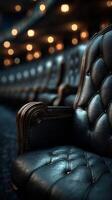 Elegant black leather chair in a dimly lit theater with blurred lights in the background photo