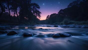 River Flowing Through Forest at Dusk Under Starry Night Sky photo