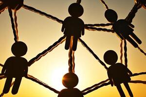 Connected silhouettes, interwoven by threads, against a sunset backdrop photo