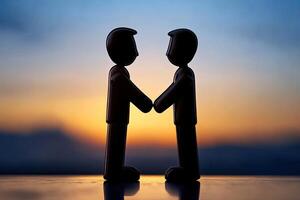 Two figures shaking hands at sunset photo
