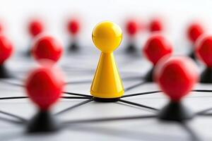 A single yellow pawn stands out amongst red and black pawns photo