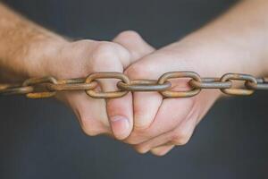 Bound hands, rusty chain photo