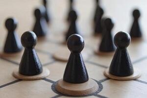 Black game pieces strategically positioned on a light-brown board photo
