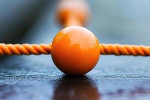 Close-up of orange sphere connected by orange rope photo