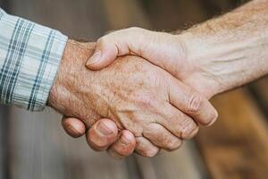 Close-up of a handshake. Two men's hands clasped firmly photo
