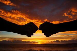 Two fists meet at sunset photo