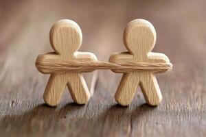 Wooden figures pulling a rope photo
