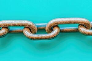 Metal chain links against teal background photo