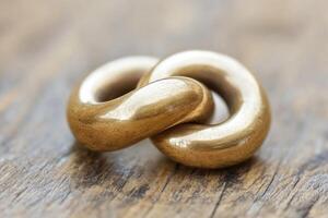 Intertwined golden rings on weathered wood photo