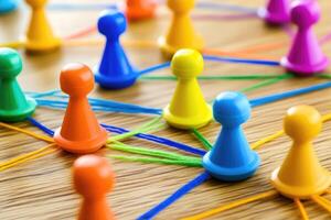 Colorful pawns connected by threads, forming a network photo