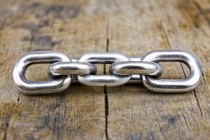 Steel chain links on a weathered wooden surface photo