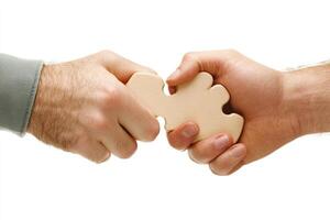 Two hands holding a wooden puzzle piece, symbolizing collaboration photo