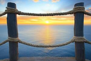 Sunrise over the ocean, framed by a wooden railing photo