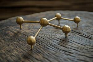 Gold-toned metal molecular structure on rustic wood photo